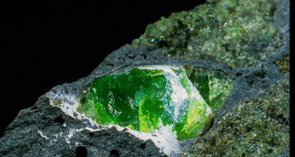 Closeup of a green forsterite crystal, an olivine mineral.
