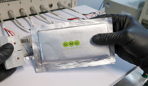 Gloved hands holding a GMG graphene-aluminum battery pouch.