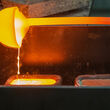 Molten rare earth metal being poured into ingot molds.