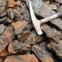 Rock hammer size reference of rare earth-bearing rock samples at Sheep Creek.