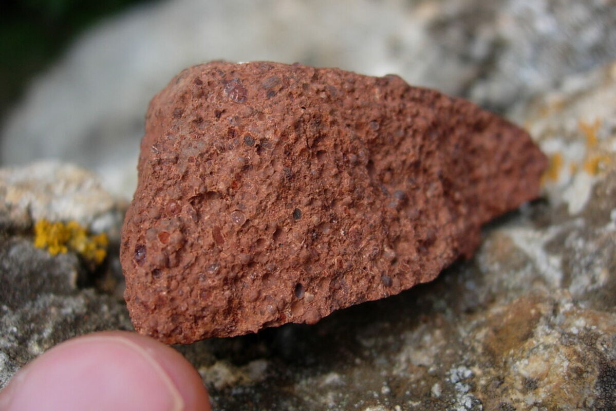 A small chunk of reddish-brown raw bauxite before it is processed into alumina.