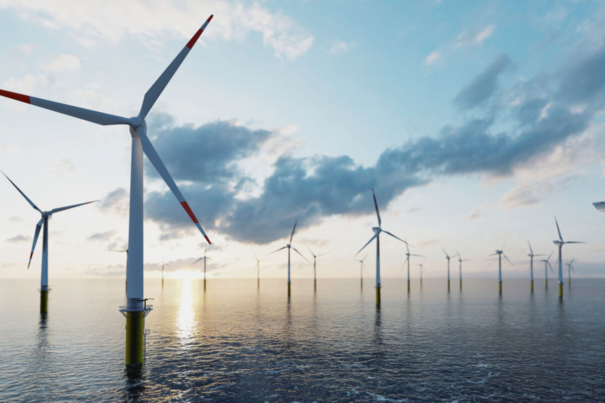 A group of offshore wind turbines generates clean energy at sunset.