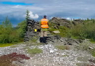 A USGS geologist collecting samples from an outcrop of rocks in Alaska.