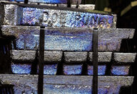 A pile of bluish silver lead bars stamped with “Doe Run.”