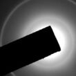 A dark square object overlaying a ring of light.