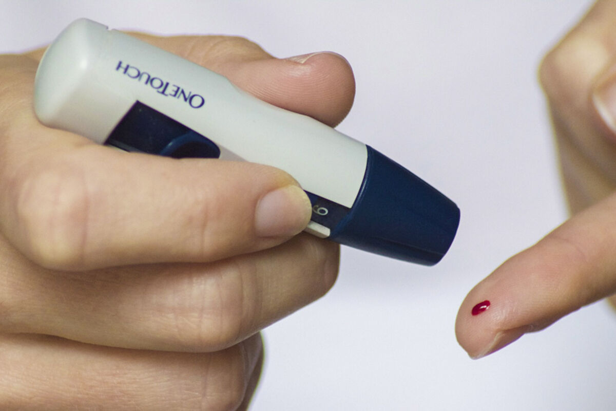 A diabetes glucose monitor pricking a finger.
