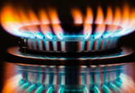 Close-up of a stovetop burner with red-tipped flames.