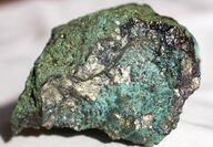 Rock sample with metallic gold mineralization coated with green copper oxides.