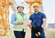 Male and female industrial employees working on a jobsite.