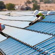 Men install First Solar CdTe thin-film photovoltaic panels.