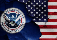 The U.S. Department of Homeland Security seal on an American flag backdrop.