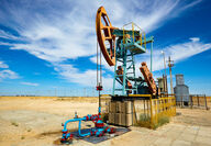 A pumpjack pumps oil from a well in an American Southwest desert.