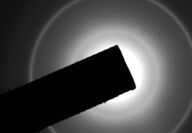 A dark square object overlaying a ring of light.