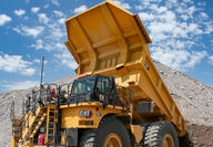 Cat 785 mining haul truck dumping material at a mine site.