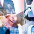 Handshake with images of wind turbines and charging electric vehicle.