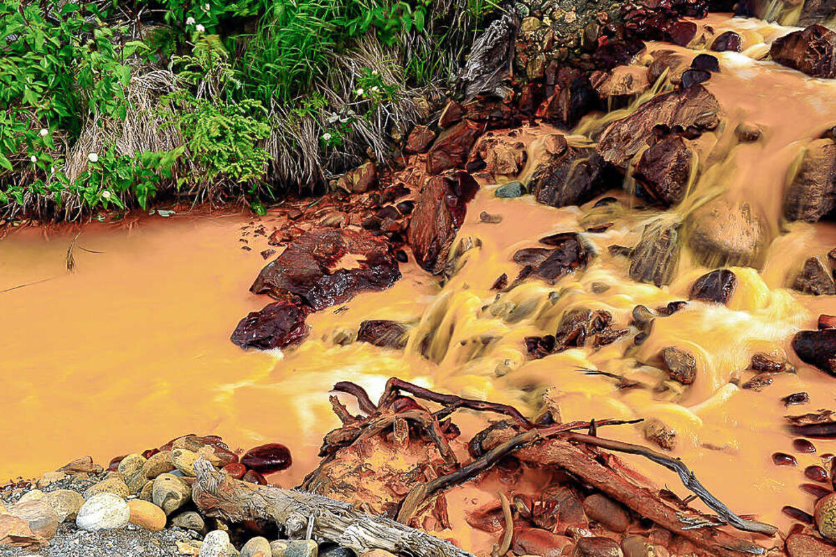 A creek colored bright orange from metals dissolved in the acidic water.