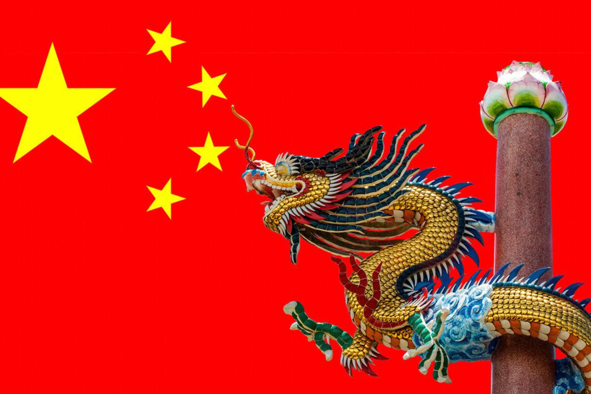 Image of a dragon in front of the flag for the People’s Republic of China.