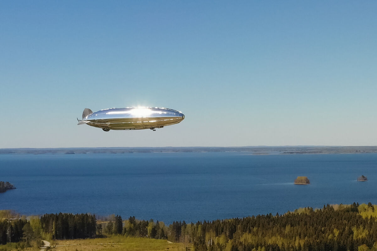 A%20silver%20hydrogen%20airship%20flies%20over%20a%20lake%20during%20the%20summer%20in%20Finland%2E