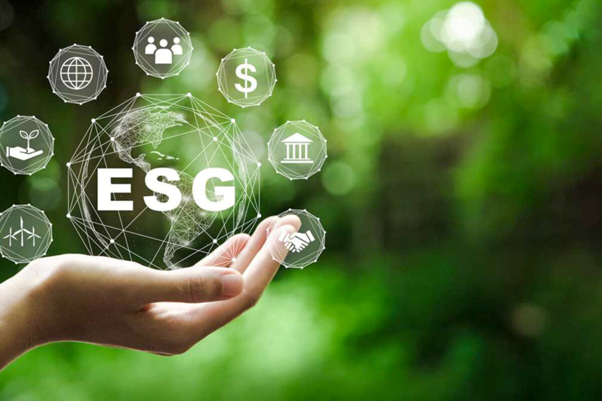 A hand holding the graphics of ESG and its various positive influences.