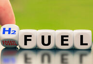 Finger flips die from “Fossil” to “H2” in front of dice spelling fuel.