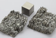High-purity scandium dendrite crystals next to one-centimeter cube.