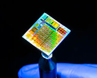A KAUST researcher displays first 2D microchip with multicolored surface.