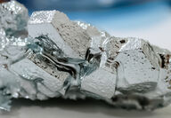 Closeup of the silvery crystalline structures of gallium in its solid state.