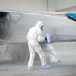 Technicians paint a plane with various coatings to protect it from corrosion.