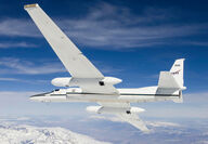 A NASA high-altitude plane in flight over snow-covered mountains.