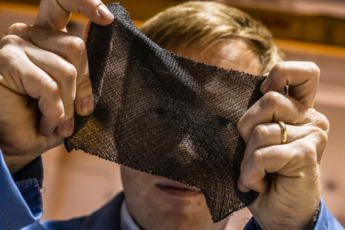 A DexMat researcher looks through a swath of Galvorn fabric.
