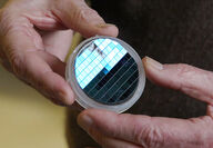Hands hold a disc of epitaxial graphene semiconductors.