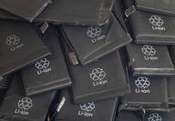Collection of black lithium cells printed with recycling symbols.