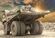 A large truck hauling a load of rocks at a mining operation.