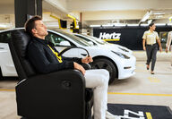 Hertz Tesla Tom Brady EV electric vehicle rental charging stations US 100,000