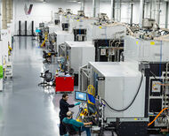 VulcanForms metal 3D printers inside a factory setting.