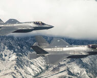 Two F-35 fighters fly training exercises over snow-covered mountains in Alaska.