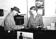A miner registers at desk at sign that reads “For Freedom’s Sake” in 1943.