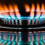 Close-up of a stovetop burner with red-tipped flames.
