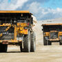 Two Cat 793 trucks haul equipped with BreadCrumbs haul ore at Fort Knox Mine.