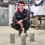 An RMIT researcher with three columns of concrete produced with PPE.