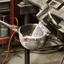Aluminum-cerium alloy being poured from a furnace into a ladle.